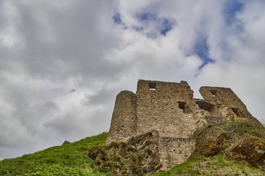 A vertical shot of the Ruins of the Lowenburg in Monreal in the Eifel in Germany with blue cloudy sky