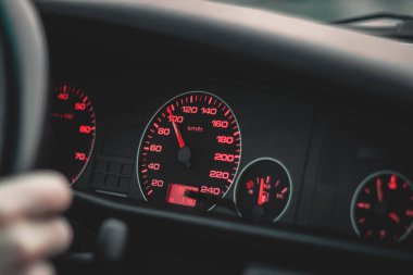 A closeup of a car speedometer dashboard showing 100 kilometers per hour
