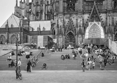 People on the stairs in front of the Cologne Cathedral in the direction of the main station, black and white photo