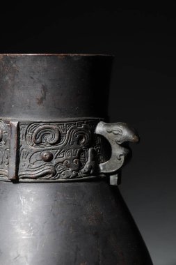 Karanlık bir arka planda izole edilmiş eski bir Çin kavanozunun yakın çekimi.