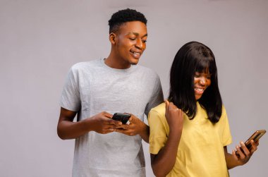 A Portrait of an African couple focused  and using gadgets spying on chatting cheating affair busted