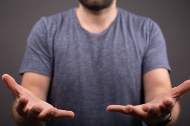 A closeup of a person with open hands on a gray background