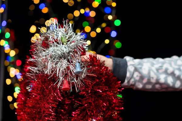 Eine Frau Hält Eine Weihnachtsdekoration Auf Dem Verschwommenen Hintergrund — Stockfoto