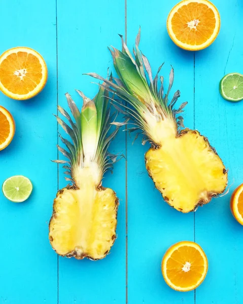 Vertical Shot Cut Pineapples Citruses Blue Wooden Surface — Photo