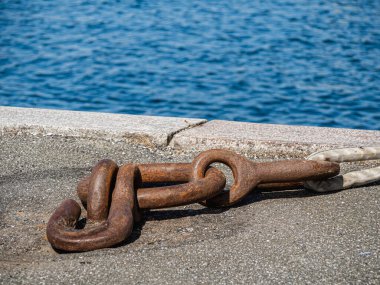 A closeup of an old rusty weathered anchor chain under the sunlight