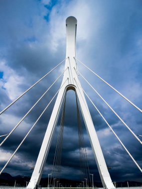 A vertical shot of a huge bridge and cloudy sky