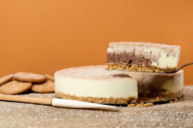 Kahverengi arka planı olan bir masada lezzetli bir kekin yakın çekimi.