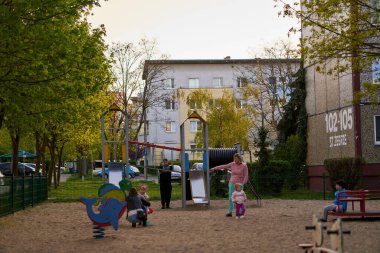 The adults and children by equipment of a playground in the Stare Zegrze area.