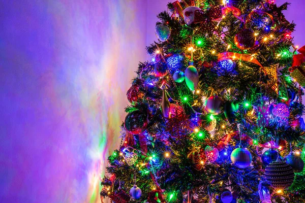 A closeup shot of the Christmas tree with lights and decorations