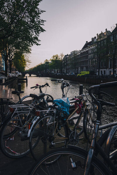 Вертикальный снимок велосипедов и зданий на заднем плане ранним утром, Амстердам, Нидерланды
