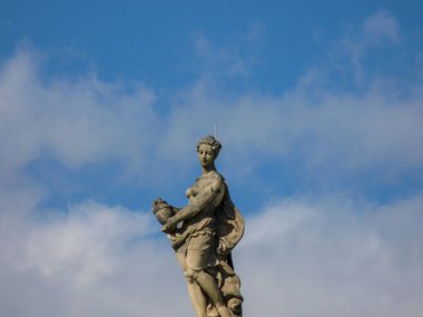 A scenic view of an old woman statue with a jug in Berlin in cloudy sky background