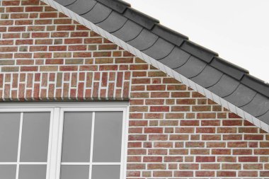 Kırmızı tuğladan evin çatısının detayları.