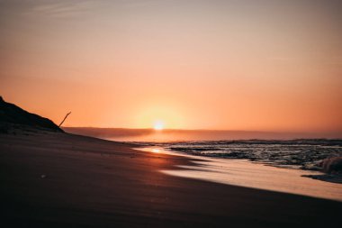 Güney Afrika 'nın doğu kıyısındaki Mossel Körfezi' nde bir sahilde gün doğumu.