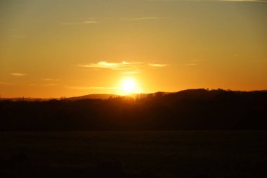 A beautiful view of a landscape with hills on a sunset sky background