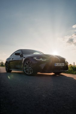 Günbatımında modern bir BMW M4 'ün, Dağ v. lüks spor arabalı görüntüsü birçok sürücünün hayalindeki arabadır.