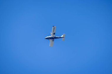 Bir hava keşif uçağı açık mavi gökyüzünde aşağı bakan bir kamerayla.