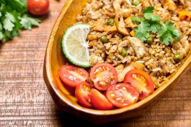 Tahta bir kasede tavuklu pirinç manzarası.