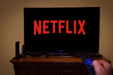 Netflix logosu ve uzaktan kumandalı bir TV ekranı