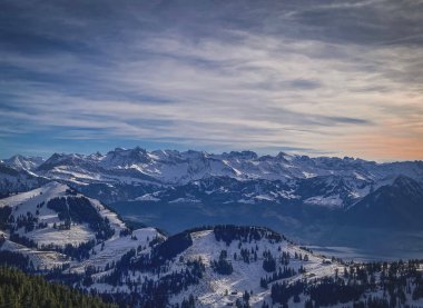 Gün batımında bulutlu bir gökyüzünün altında karla kaplı güzel bir yüksek açı.
