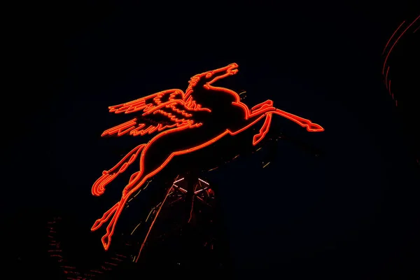 Bir Neon Kırmızı Pegasus Bir Lunaparkta Karanlık Bir Gökyüzü Arka — Stok fotoğraf