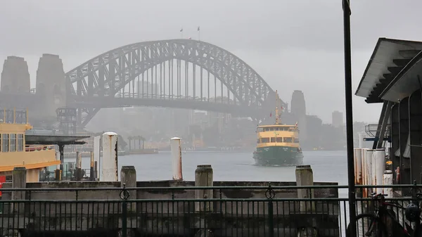 A Sydney ferry harbor bridge wharf on a foggy day