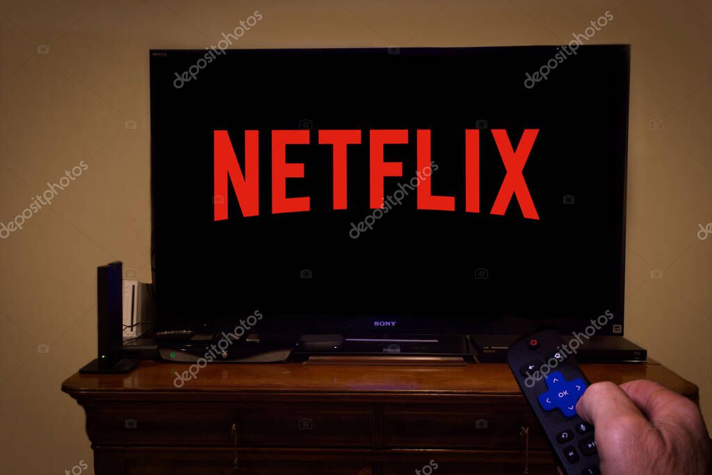 TV screen with Netflix logo and hand holding remote control
