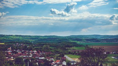Arkasında bulutlu bir gökyüzü olan bir köy.