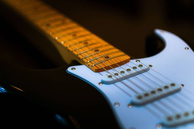Elektro gitarın tellerindeki detayların yakın plan çekimi.