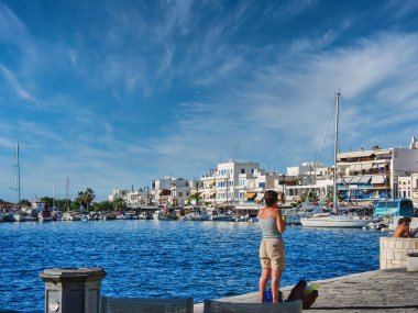 Yunanistan 'ın Naxos kentinde güneşli bir iskelede duran güneş yanığı bir insan