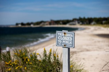 Gri, ahşap, kapalı alan tabelasına yakın çekim ve plaja karşı bir yazı. Harkness Eyalet Parkı.