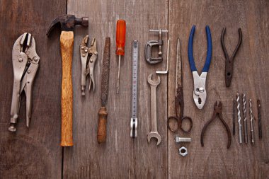 Bir atölyedeki ahşap bir tahtanın üzerinde bir takım aletler.