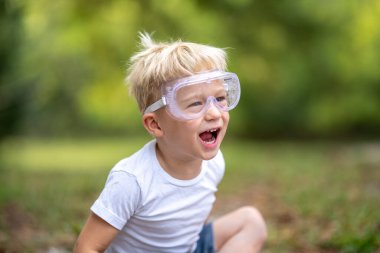 İki yaşında, koruyucu gözlüklü bir çocuk.