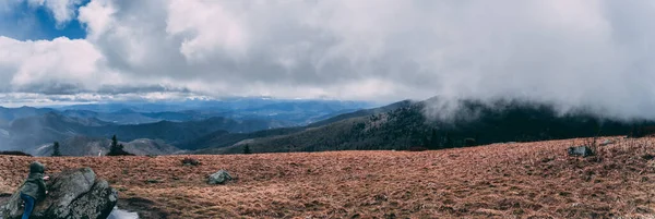 A panoramic shot of beautiful mountains and clouds