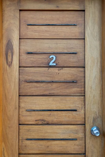 A closeup of a wooden door with number 2
