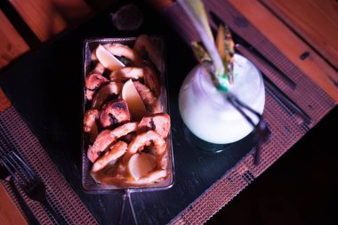 Yanında soğuk bir kokteyl olan küçük bir soğan halkası.