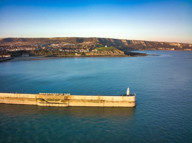 Açık mavi gökyüzünün altında iskelesi olan güzel bir deniz manzarası.