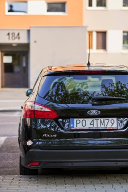 Bir apartmanın yakınındaki park yerinde park edilmiş Ford marka bir araba..