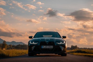 Günbatımında modern bir BMW M4 'ün, Dağ v. lüks spor arabalı görüntüsü birçok sürücünün hayalindeki arabadır.