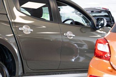 Sergi salonundaki metalik koyu kahverengi arabanın kapısına yakın çekim..