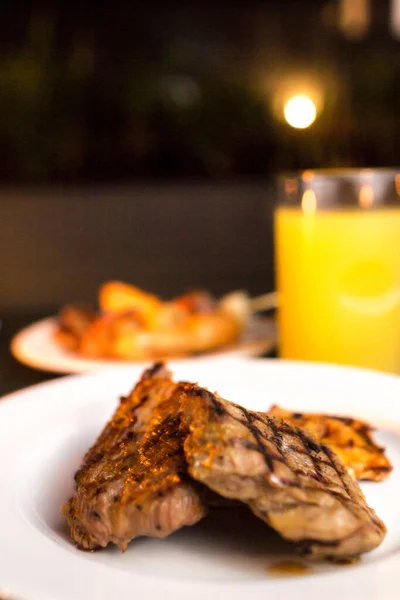 A selective focus shot of a plate of grilled meat on a restaurant table