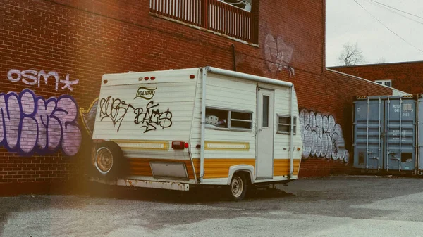 Pequeno Reboque Branco Frente Uma Parede Tijolo Com Graffiti — Fotografia de Stock