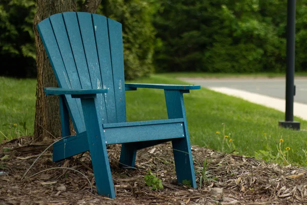 A closeup of a blue wooden chair in a park