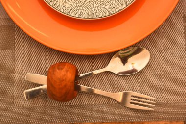 Gümüş çatal, kaşık ve renkli tabakların yakın çekimi.