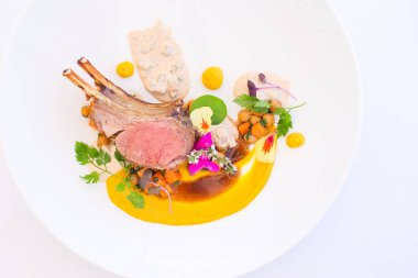 Beyaz tabağın üst görüntüsünde soslu et ve beyaz izole edilmiş arkaplanda biraz sebzeli Tahini var.