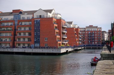 Dublin 'deki IFSC liman havzalarının etrafına inşa edilen gümrük binası. Deniz kenarında evleri olan resimli bir site..