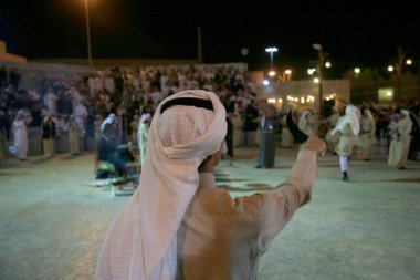 An Arabian young man standing with a dagger