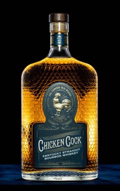 A vertical shot of a bottle of Chicken Cock Kentucky Straight Bourbon Whiskey on black background