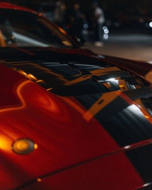 A closeup of a red sport car at night