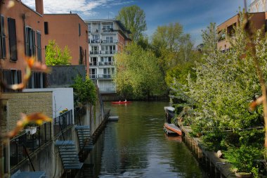 Gündüz vakti binalar boyunca akan güzel bir nehir manzarası.