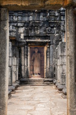 Arka planda Buda heykeli olan Sri Lanka 'daki eski bir Budist binasının dikey görüntüsü.